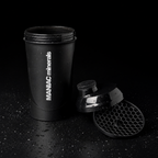 MANIAC Shaker 700 ml zerlegt: offene Flasche, Schraubdeckel mit Trinköffnung und herausgenommenes Wabensieb auf schwarzem Untergrund